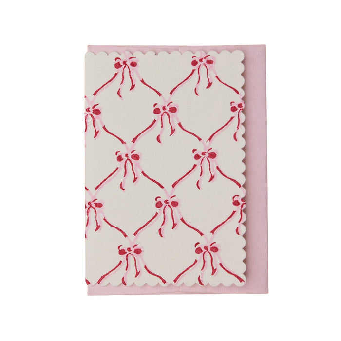 Block printed cotton greeting card with red bow pattern on a white background.
