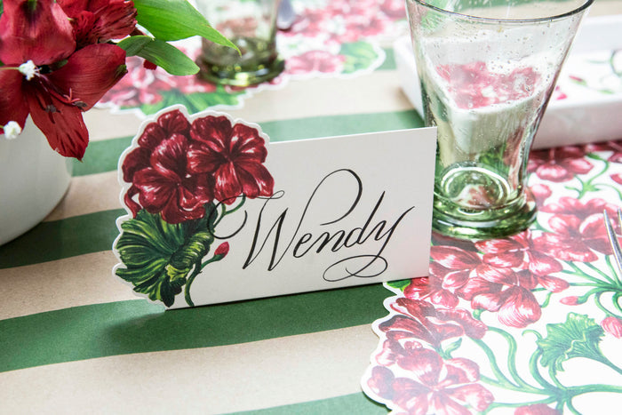 A Geranium Place Card labeled "Wendy" on an elegant floral table setting.