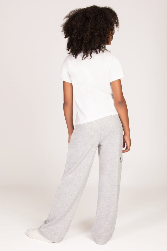 A child model shown from the back wearing a white short-sleeve t-shirt and light grey wide-leg sweatpants against a plain light background.
