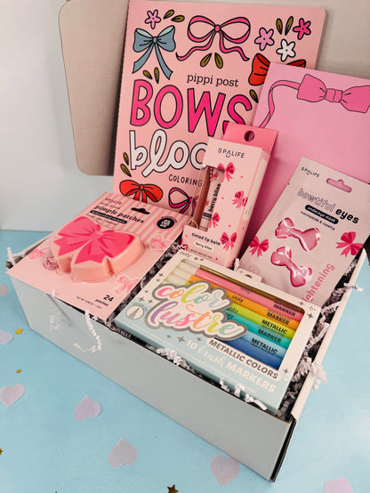 Coloring book and stationery items with bows on a light blue background