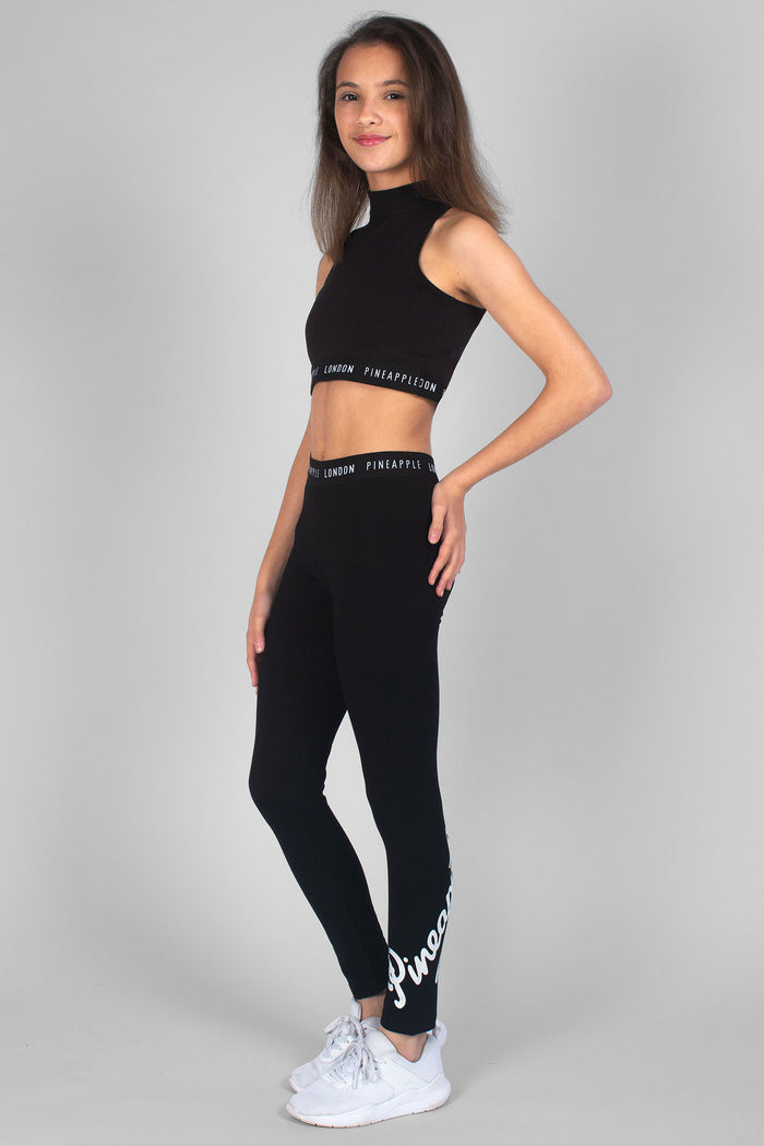 Girl wearing sleeveless black Barbarella Crop Top and black Mesh Crop Leggings