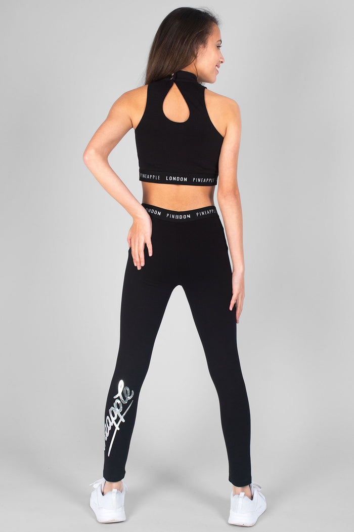 Girl wearing black Barbarella Crop Top and black Mesh Crop Leggings with logo