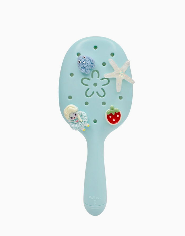 Light blue hairbrush with ocean-themed decorations on a white background