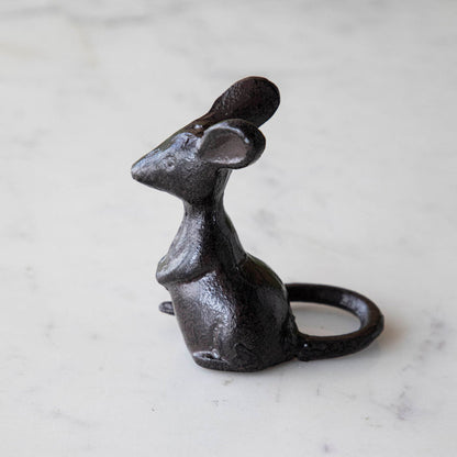 A cast iron mouse on a marble table.