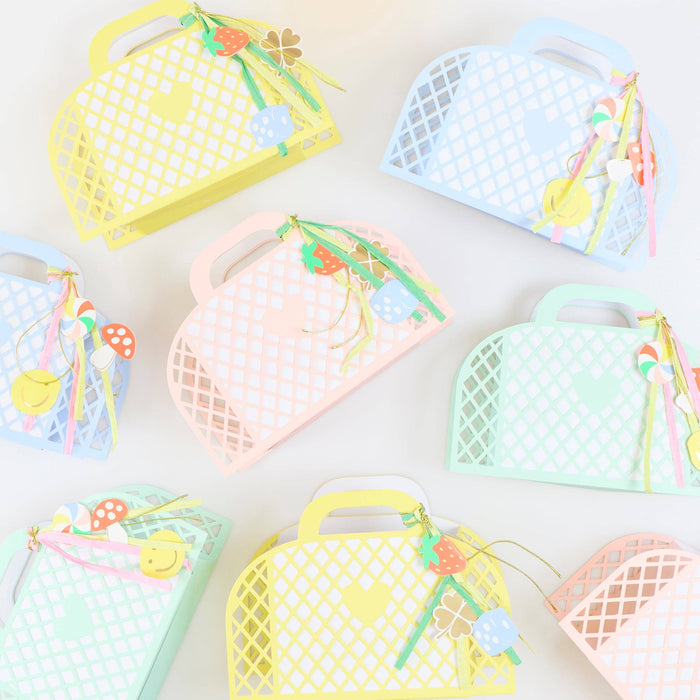 Colorful mesh bags with handles and decorative elements on a light background