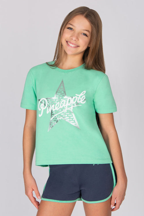 Girl wearing a light blue t-shirt with a star print, standing against a plain background