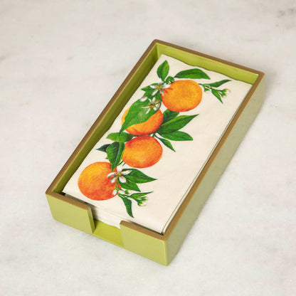A green lacquered wood beverage napkin caddy with gold trim, featuring a napkin  with an orange pattern.