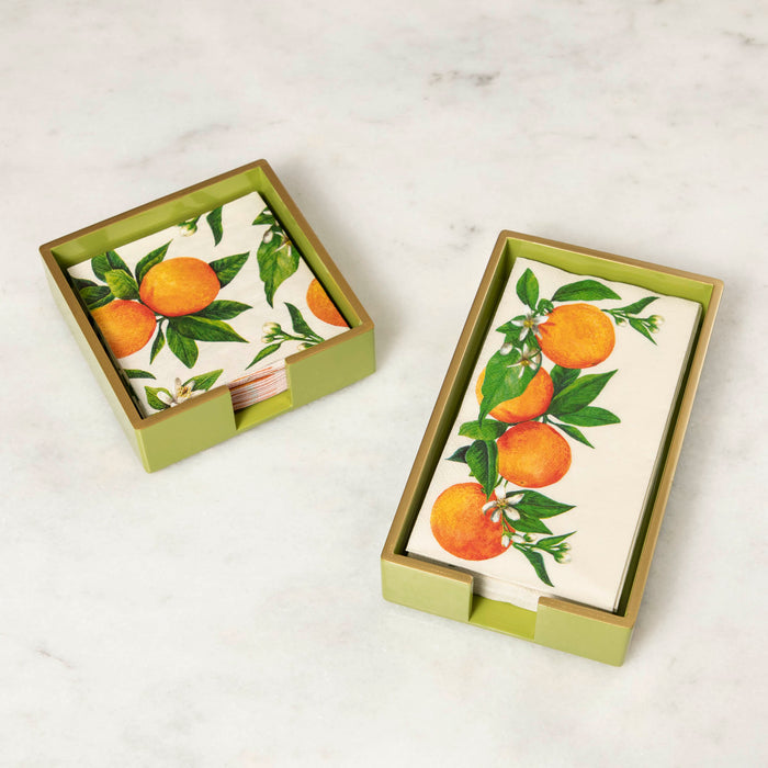 A green lacquered wood beverage and guest napkin caddy with gold trim, featuring a napkin with an orange pattern.