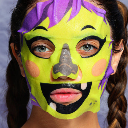 Person wearing a colorful mask with purple, yellow, and black design on a light gray background