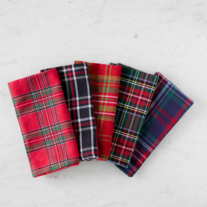 A collection of folded plaid patterned cloth napkins in various colors, displayed on a white surface.