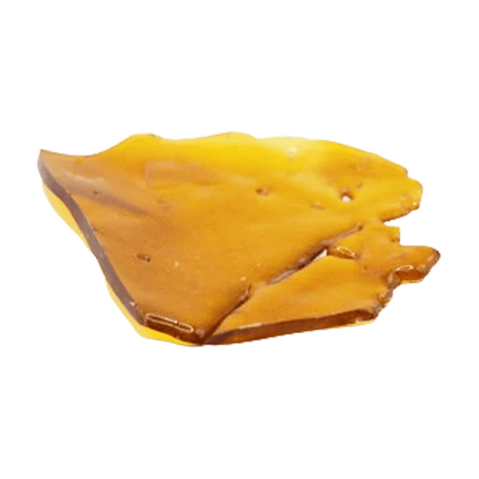Close-up top-down view of a glossy amber shard of Indica Shatter resting on a white background.