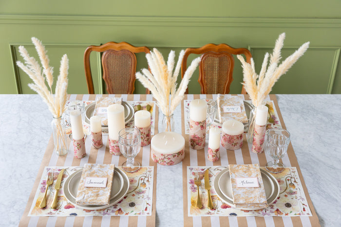 Set table with Blush Pressed Petals Placemats, cutlery, and candles on the Kraft White Classic Stripe Runner.
