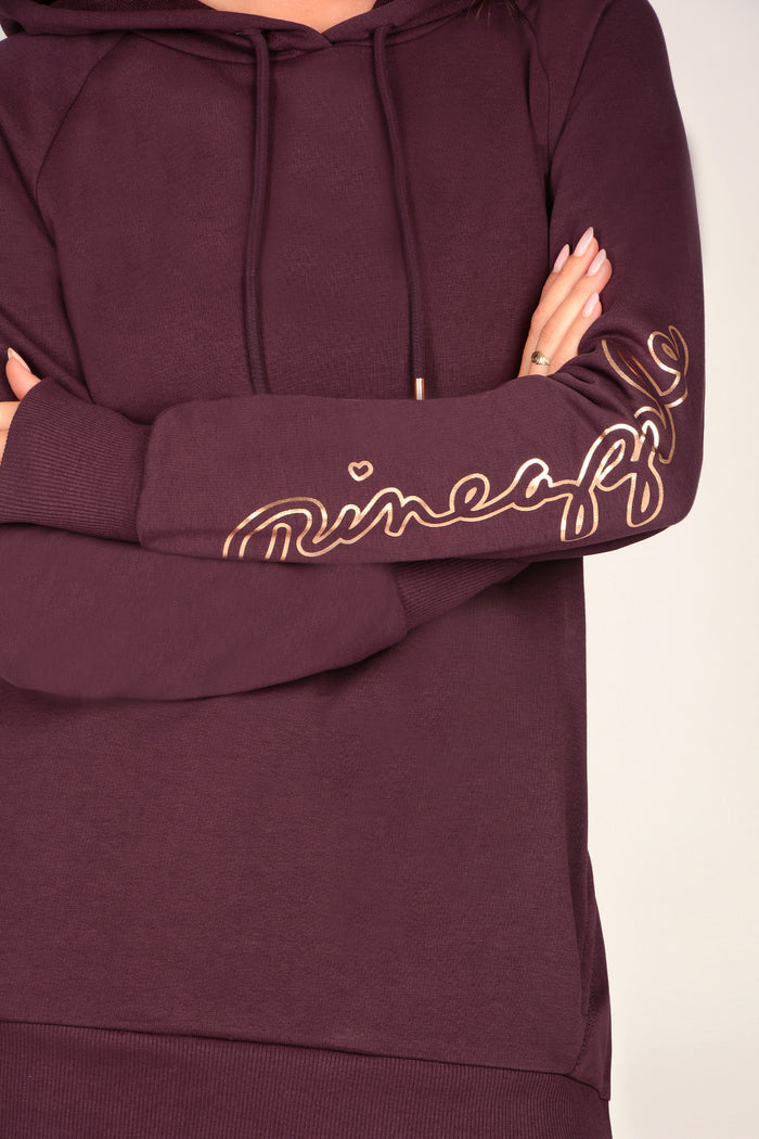 Detail shot of women's maroon brown hoodie with rose gold detailing.