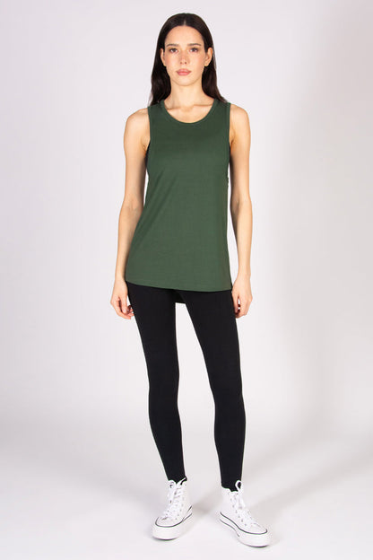 Woman wearing a khaki tank top and black leggings on a white background