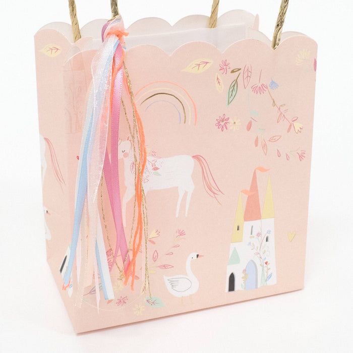 Pink gift bag with unicorn and castle designs on a white background