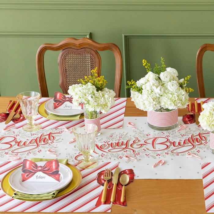 The Merry & Bright Runner styled under a Christmas table setting with the Bow Place Cards and table accents and Peppermint Stripe Placemat.