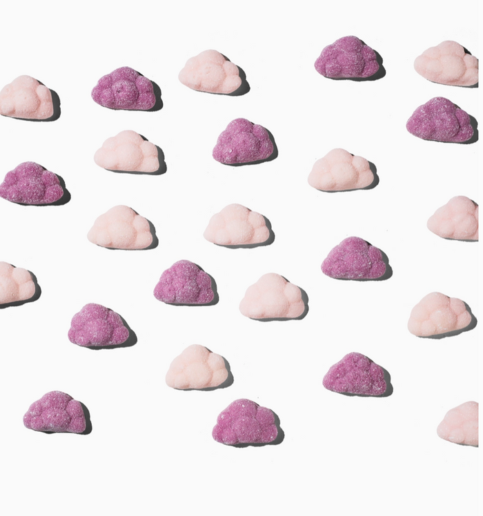 Pattern of pink and purple cloud-shaped candies on a white background