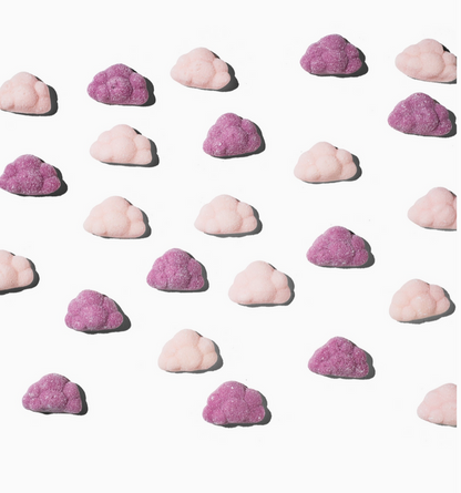 Pattern of pink and purple cloud-shaped candies on a white background