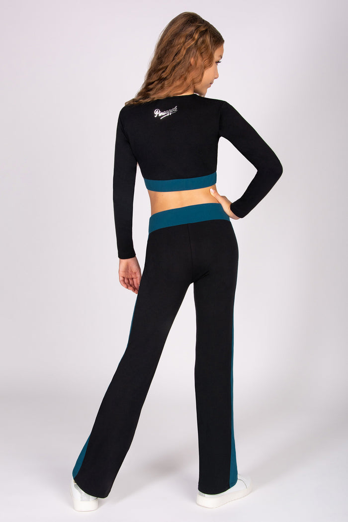 Girl wearing a black and teal outfit with a brand logo on a white background