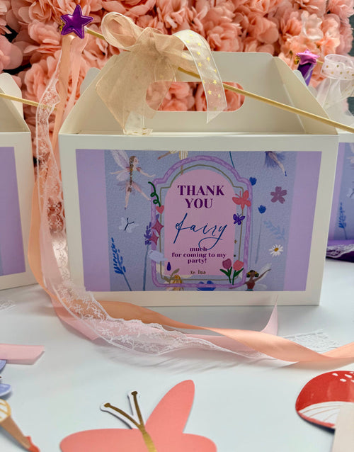 Gift box with fairy-themed design and pink ribbon on a floral background