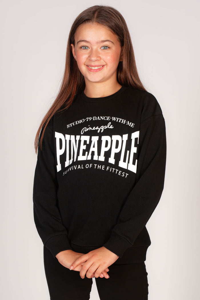 Kids' black oversized sweatshirt with Pineapple survival logo across chest.