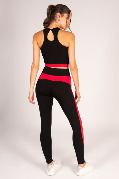 Women's black and red yoga outfit, featuring a mid length crop top and high waisted leggings.