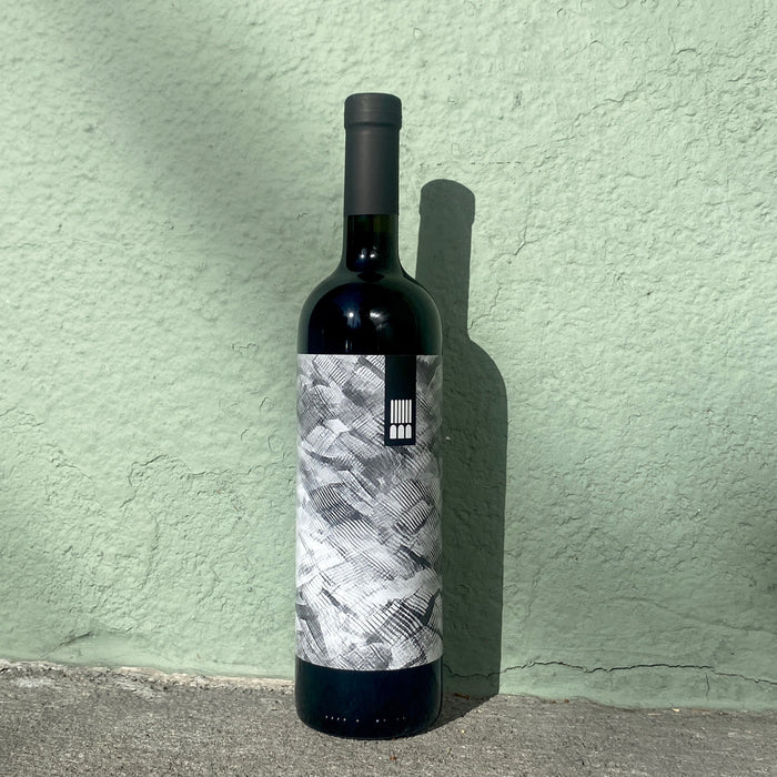 Santuvario red wine bottle 2018 with dark glass, black cap, and monochrome textured label