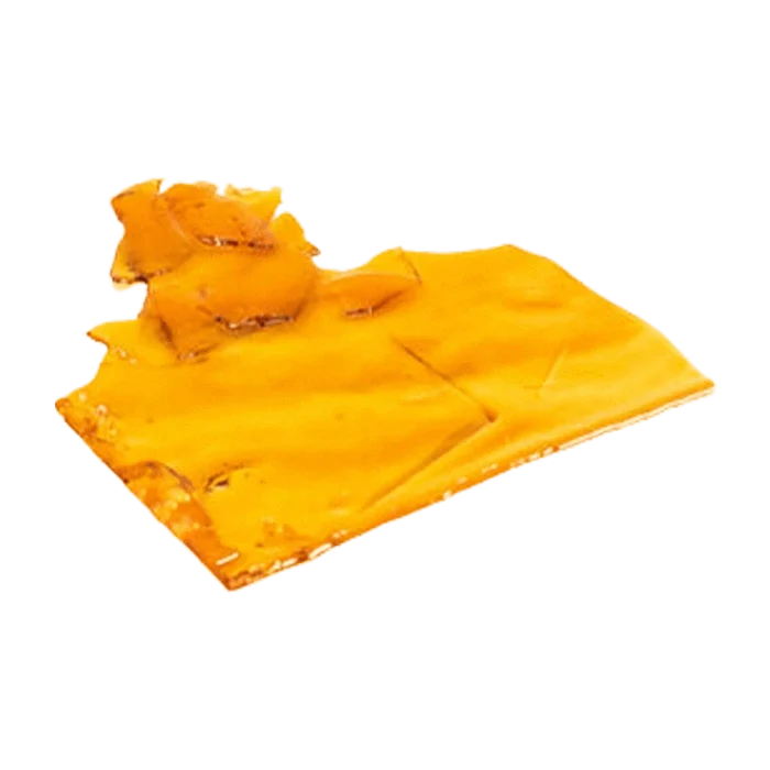 Close-up, angled view of a glossy amber slab of Sativa Shatter resting on a white background.