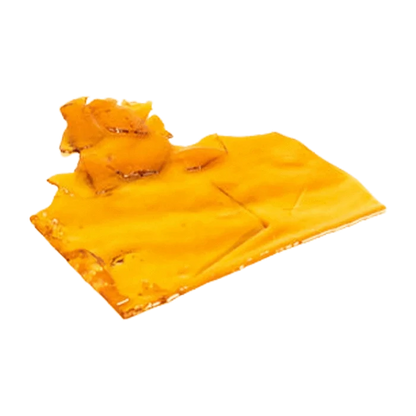 Close-up, angled view of a glossy amber slab of Sativa Shatter resting on a white background.