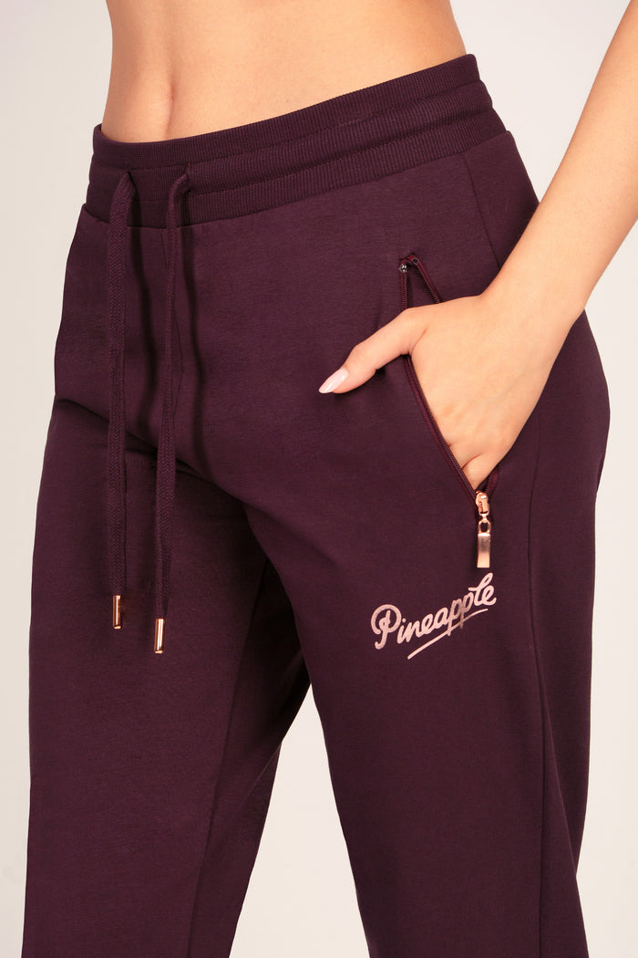 Detail shot of maroon brown joggers with zip pockets and drawcord waistband.