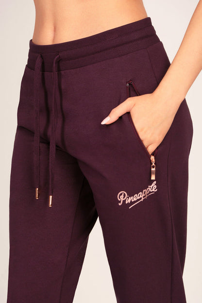 Detail shot of maroon brown joggers with zip pockets and drawcord waistband.