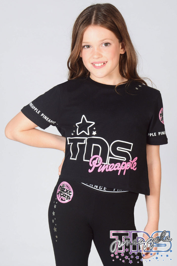 Girl wearing black The Next Step Crop T-Shirt with matching TNS Star Leggings in black.