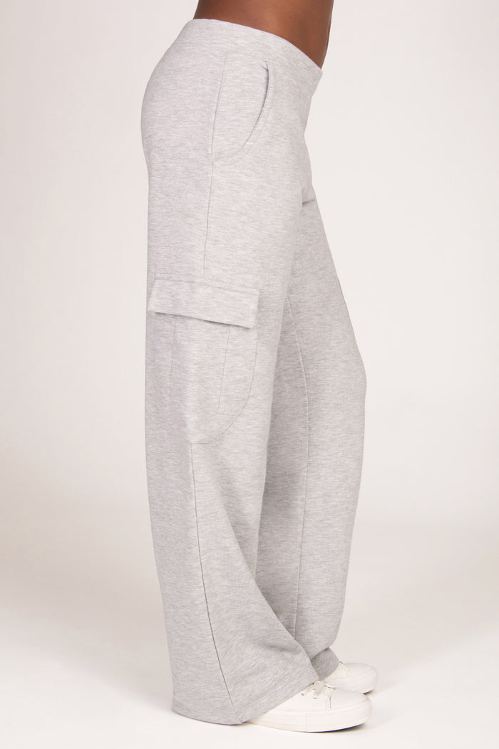 Light grey marl wide-leg sweatpants with a cargo pocket on the side, shown on a model from the waist down wearing white trainers against a plain light background.